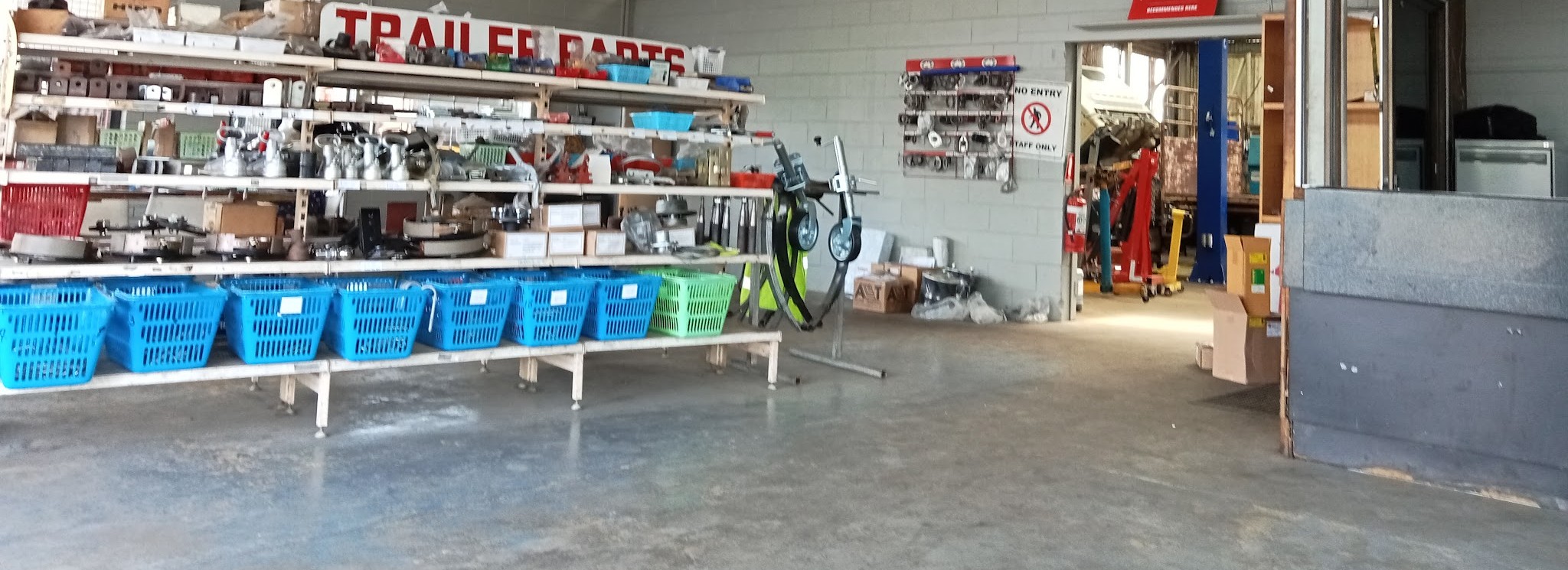 The trailer parts counter at Geben Mechanical, with the workshop and vehicle hoist through the doorway beyond